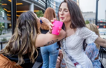 Two girls chucking their drinks on a bachelorette party